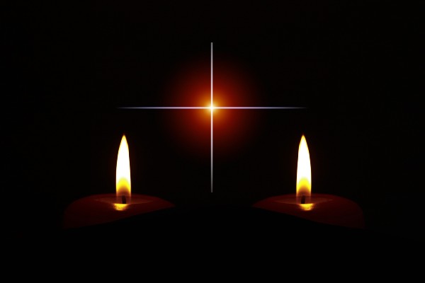 Deux chandelles dans la nuit avec un faisceau lumineux au loin en forme de croix