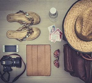 Pour une voyageuse: Articles déposés et bien rangés-Sac-Chapeau-Caméra-Cellulaire-Tablette électronique-Sandale-Billets-Bouteille d'eau-Verres fumés