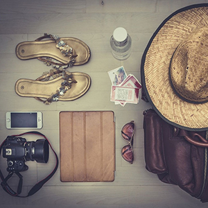 Pour une voyageuse: Articles déposés et bien rangés-Sac-Chapeau-Caméra-Cellulaire-Tablette électronique-Sandale-Billets-Bouteille d'eau-Verres fumés