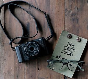 Caméra photo avec une paire de lunettes et citation: Life is better with friends