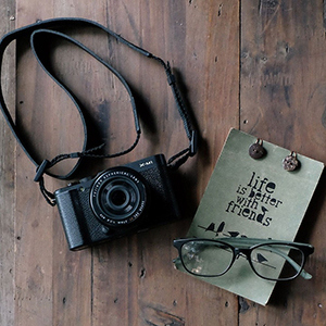 Caméra photo avec une paire de lunettes et citation: Life is better with friends