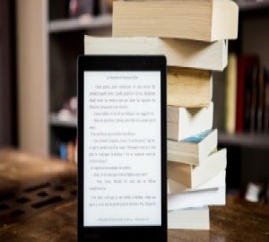 Livres empilés et liseuse électronique appuyée sur cette pile.